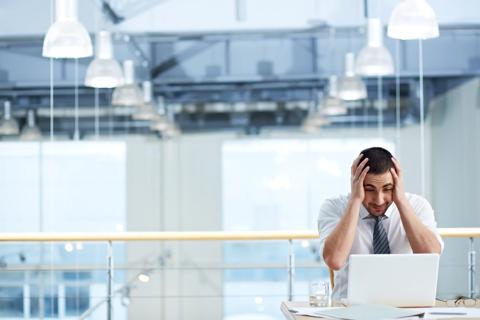 Manager looking at his laptop in despair