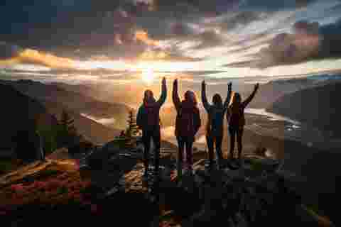 Hikers enjoying golden hour landscape view over the mountains.