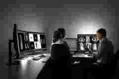 A radiologist showing diagnostic images to a colleague using Barco Coronis Fusion 6MP displays