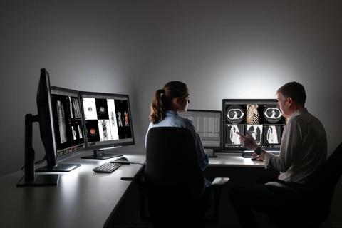 A radiologist showing diagnostic images to a colleague using Barco Coronis Fusion 6MP displays