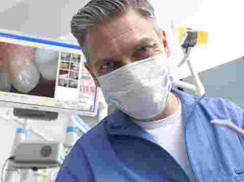 dentist looking into camera with white Eonis in background
