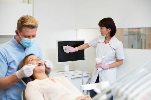 dental practice with dentist, patient and assistant cleaning a white Nio dental display