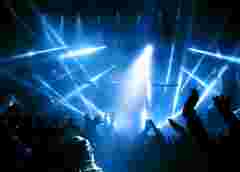 Silhouettes of people and musicians in big concert stage. Bright beautiful rays of light