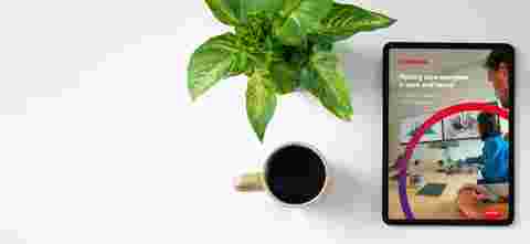 Office desk table with tablet,coffee cup ,pencil ,flower ,notepad on white desk. Top view with copy space.