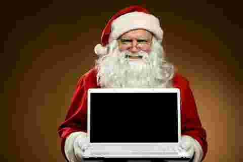 Traditional Santa Claus with a modern laptop. Add your text or picture.