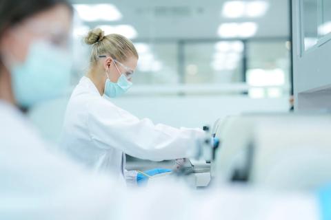 Medical laboratory technologist calibrating spectrophotometer wavelength accuracy. Clinical scientist adjusting centrifugation rpm parameters for plasma separation.