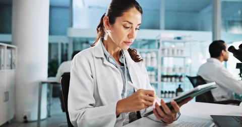 Scientist, woman and medical research with tablet at lab with writing, review and notes for pharma job. Person, gloves and equipment with application for vaccine development, trial and clinical study.