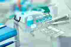 Blurred background for histopathology-related presentation. Stained histological tissue samples on glass, fixed tissue, automatic pipette and other work-related tools. Toned image, text space. 