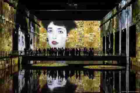 Visitors at immersive Klimt exhibition at Bassins de Lumières, Bordeaux, France, a Culturespaces artainment space powered Barco projection mapping. 
