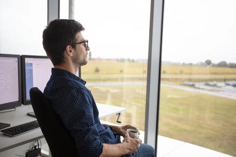 A satisfied PACS manager looking through a window