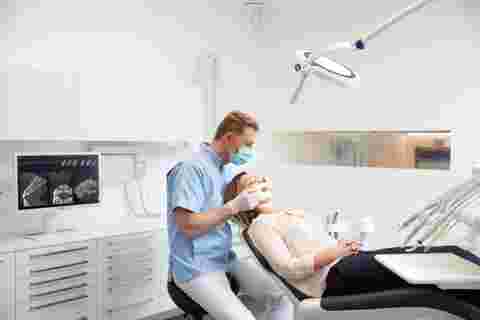 Dental practice with white Nio display, dentist, patient