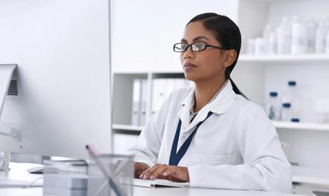 Woman, science and reading in laboratory by computer, review or thinking for solution at pharmaceutical company. Person, pc and innovation for medicine, drugs or research with medical journal on web.