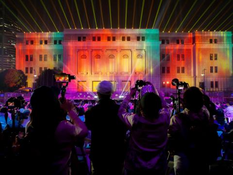 Audience looking at projection mapping show on Shanghai concert hall with Barco UDX projectors