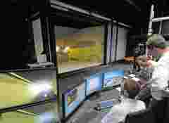Scientists during the official opening and demonstration of the new 3D virtual reality visualization system, provided by Barco, at the University of Wuerzburg, Department of Psychology, in Wuerzburg, Thursday, July 26, 2012. (AP Photo/Jens Meyer)