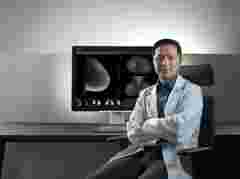 Radiologist looking confident at camera lens, with crossed arms