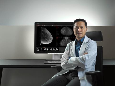 Radiologist looking confident at camera lens, with crossed arms
